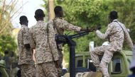 Members of Sudan's Rapid Support Forces (RSF) paramilitaries wait in a security detail as the country's ousted president appears before prosecutors over charges of corruption and illegal possession of foreign currency, in the capital Khartoum on June 16, 