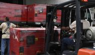 A worker unloads generators received as part of humanitarian aid through the Venezuelan Red Cross in Caracas, Venezuela on June 17, 2019. / AFP / YURI CORTEZ