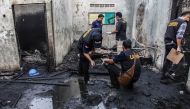 Investigators work on the scene of a burnt-out house that doubled as a matchstick factory in Binjai on June 21, 2019, following a fire on the premises that killed at least 30. AFP / Ivan Damanik 