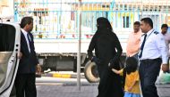 Michael Jackson, wearing an abaya, a traditional Arab women's veil, holds the hand of a child as he is escorted to his car by a shopping mall security agent in Manama, Bahrain, January 25, 2006.