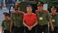 US citizen Michael Nguyen is escorted by policemen before his trial at a court in Ho Chi Minh city, Vietnam June 24, 2019. REUTERS/Stringer