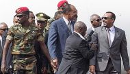 FILE PHOTO: Eritrea President Isaias Afwerki (C) is welcomed by Ethiopia Prime Minister of Abiy Ahmed (R) and Seare Mekonnen (C left) as he arrives at the Bole International airport in Addis Ababa on July 14, 2018. / AFP / MAHEDER HAILESELASSIE TADESE