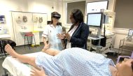 Midwifery educator at Middlesex University Sarah Chitongo instructs a trainee midwife wearing an augmented reality (AR) headset in London, Britain June 17, 2019.  Reuters/Stuart McDill