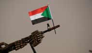 A Sudanese national flag is attached to a machine gun of Paramilitary Rapid Support Forces (RSF) soldiers as they wait for the arrival of Lieutenant General Mohamed Hamdan Dagalo, deputy head of the military council and head of RSF, before a meeting in Ap