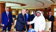 Sheikh Faisal bin Qassim Al Thani (right), Chairman of Aamal Company, shaking hands with GPI’s International Sales Director Fabio Rossi after signing the agreement. Italy’s Ambassador to Doha, Pasquale Salzano (standing behind Rossoi), and other dignitari