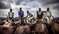 A group of herdsmen selling cows wait for costumers at Kara Cattle Market in Lagos, Nigeria, on April 10, 2019. AFP / Luis Tato 