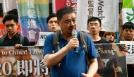 Chinese dissident Wuer Kaixi (C) speaks during a rally outside the Hong Kong Economic, Trade and Culture office in Taipei on June 27, 2019, calling for leaders of G20 nations to confront fellow member China following massive protests in Hong Kong against 
