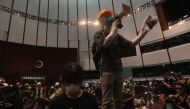A protester uses a loudspeaker after they broke into the parliament chamber of the government headquarters in Hong Kong on July 1, 2019, on the 22nd anniversary of the city's handover from Britain to China. (AFP / VIVEK PRAKASH)