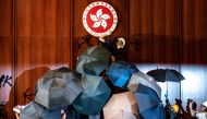 A protester defaces the Hong Kong emblem after protesters broke into the government headquarters in Hong Kong on July 1, 2019, on the 22nd anniversary of the city's handover from Britain to China. AFP / Philip Fong 