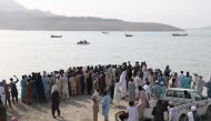 In this picture taken on July 3, 2019, Pakistani onlookers gather at the edge of the Indus River after a boat capsized in Haripur district. AFP / ATIF HUSSAIN