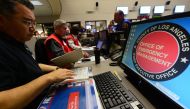 Participants from the I.T (L) and Disaster Management (C/R) work side by side at the Command Center of the Office of Emergency Management in Los Angeles, California, during a functional exercise for first responders in a simulated 7.8 magnitude earthquake