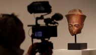 A cameraman films an Egyptian brown quartzite head of the God Amen which will be sold at auction at Christie's in London, Britain, July 4, 2019. Reuters/Peter Nicholls