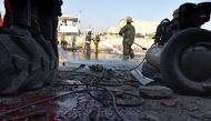 Afghan firefighters washing a road at the site of a suicide car bomb perpetrated by a Taliban bomber near the international airport in Kabul on December 27, 2015. AFP/Shah Marai