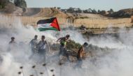 Demonstrators are affected by tear gas smoke launched by Israeli security forces as they intervene in a demonstration within the 