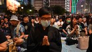 People offer prayers during a vigil in Hong Kong on July 6, 2019, in memory for four youths who had taken their lives in recent weeks as Hong Kong is rocked by anti-government protests. (AFP / HECTOR RETAMAL)