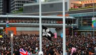 Anti-extradition bill protesters raise a black Hong Kong flag next to a Union flag outside the West Kowloon Express Rail Link Station during a march at Hong Kong's tourism district Tsim Sha Tsui, China July 7, 2019. REUTERS/Tyrone Siu