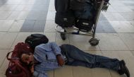 A stranded passenger sleeps next to his luggage as he waits for the delayed flight after an airplane overshot the runway while landing due to heavy rains at the Chhatrapati Shivaji International airport in Mumbai, India July 2, 2019. Reuters/Prashant Wayd