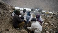 In this picture taken on May 18, 2019, road maintenance workers from India's low-lying eastern Jharkhand state warm up around a bonfire during a inclement weather while working along Pangong Lake road near the Chang La pass in northern India's Ladakh regi