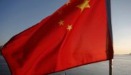 N Korean fishermen are seen as a Chinese flag flutters from the Broken Bridge as the sun sets over Yalu River between N Korean town of Sinuiju Dandong in Liaoning Province, China, Nov 19, 2017. Reuters/Damir Sagolj