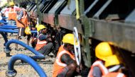 Labourers connect pipes to collect water from a special train of 50 wagons carrying litres of water at Villivakkam railway station in Chennai on July 12, 2019.  AFP / Arun Sankar 