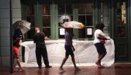 A worker seals the front of a restaurant along Bourbon Street from floodwater as rainfall from Hurricane Barry begins on July 12, 2019 in New Orleans, Louisiana. Scott Olson/Getty Images/AFP
