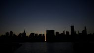 The sun sets behind 42nd Street in Manhattan during a power outage in New York City on July 13, 2019. AFP / Johannes Eisele 