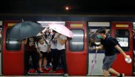 Protesters stop the door of a Mass Transit Railway (MTR) subway from closing to allow more protesters to board the train to retreat after a clash with police at a shopping mall, in Hong Kong, China July 14, 2019. Reuters/Tyrone Siu
 