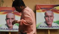 An Indian resident walks past placards with the picture of Kulbhushan Jadhav, an Indian national convicted of spying in Pakistan, in the neighborhood where he grew up, in Mumbai on July 17, 2019. AFP / Indranil Mukherjee 