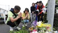 Residents pray for victims of a fire which hit the Kyoto Animation company studio the day before, killing 33 people, in Kyoto on July 19, 2019. (AFP / JIJI PRESS)