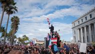 Puerto Rican rapper Rene Perez, aka Residente, (C) speaks alongside Puerto Rican reggaeton singer Bad Bunny (top) and Puerto Rican actor Benicio del Toro as they take part of a demonstration demanding Governor Ricardo Rossello's resignation in San Juan, P