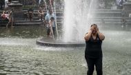 A woman cools off in the fountain at Washington Square Park during a hot afternoon day on July 17, 2019 in New York City. Drew Angerer/Getty Images/AFP