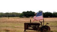 FILE PHOTO:  A tattered US flag flies on an old tractor in a farm field outside Sutherland Springs, Texas, November 8, 2017. Reuters/Rick Wilking