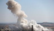 Smoke billows above buildings during a reported air strike by pro-regime forces on Khan Sheikhun in the Syria's Idlib province on July 19, 2019.  AFP / Omar Haj Kadour
