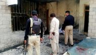 Pakistani security officials examine the site of a suicide bomb attack at the entrance of a hospital in Kotlan Saidan village on the outskirts of the northwestern city of Dera Ismail Khan on July 21, 2019. (AFP / Adil Mughal)