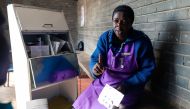 Nurse Angela Chikondo instructs Blessing Chingwaru, 29, an HIV positive TB patient on how he should take medication received as part of his treatment at Rutsanana Polyclinic in Glen Norah township, Harare June 24, 2019. AFP / Jekesai Njikizana 
