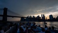 People sit on a ferry while the sun sets behind the skyline of Lower Manhattan on July 21, 2019 in New York City. An oppressive heat wave stretching from the Midwestern plains to the Atlantic coast had nearly 150 million people struggling to stay cool in 