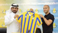 Al Gharafa’s new signing, Algerian international Sofiane Hanni holding a team jersey with an official during the official unveiling of the former Spartak Moscow player  in Doha, yesterday.