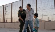 In this file photo taken on May 16, 2019, José, 27, with his son José Daniel, 6, is searched by US Customs and Border Protection Agent Frank Pino in El Paso, Texas. (AFP / Paul Ratje)