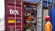 In this handout picture provided by Sri Lankan Customs on July 23, 2019, a customs official inspects the load of a container at a port in Colombo. Sri Lanka customs on July 23 ordered the return of container loads of hazardous mortuary and clinical waste 
