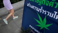 FILE PHOTO: A woman walks by an election campaign poster for a party promoting the legalisation of cannabis for medical use, in Bangkok, Thailand, February 15, 2019. REUTERS/Soe Zeya Tun