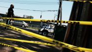 A man walks by police tape in the Brownsville neighborhood in Brooklyn where one person was shot and killed and 11 others were injured after two or more shooters opened fire during a massive block party on July 29, 2019 in New York City.  Spencer Platt/AF