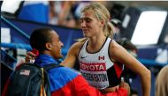 Brianne Theisen Eaton of Canada is embraced by her husband decathlon Olympic and world champion Ashton Eaton of the US after the women's heptathlon 800 metres heat event of the IAAF World Athletics Championships at the Luzhniki Stadium in Moscow, Russia, 