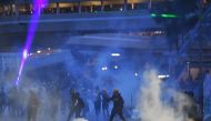 Protesters throw back tear gas cannisters fired by the police in Tai Wai in the New Territories of Hong Kong on August 10, 2019. (AFP / Manan VATSYAYANA)