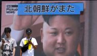 Pedestrians walk past a giant screen in Tokyo reporting about North Korea's missile launch earlier in the day, on August 10, 2019. (AFP / Kazuhiro NOGI)