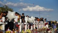 FILE PHOTO: People gather to pay their respects at a growing memorial three days after a mass shooting at a Walmart store in El Paso, Texas, U.S. August 6, 2019. REUTERS/Callaghan O'Hare