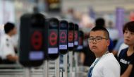 People are seen next to the temporary closed security gates as anti-extradition bill demonstrators protest at the departure hall of Hong Kong Airport, China August 12, 2019. REUTERS/Issei Kato
