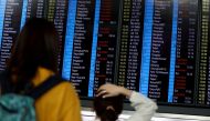 Passengers react as they look at the flight information board as the airport reopened a day after flights were halted due to a protest, at Hong Kong International Airport, China August 13, 2019. REUTERS/Issei Kato