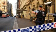 Police gather at the crime scene after a man stabbed a woman and attempted to stab others in central Sydney on August 13, 2019, before being pinned down by members of the public and detained by police.  / AFP / SAEED KHAN