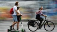 A cyclist passes two people riding an E-Scooter in Berlin, Germany, August 10, 2019. (REUTERS/Annegret Hilse)