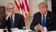 FILE PHOTO: In this file photo taken on March 06, 2019 US President Donald Trump speaks alongside Apple CEO Tim Cook (L) during the first meeting of the American Workforce Policy Advisory Board in the State Dining Room of the White House in Washington, DC